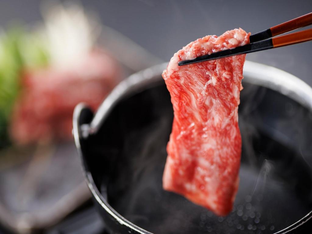 Un morceau de viande est en train de griller sur un gril dans l'établissement Nanki Shirahama Wan Wan Paradise Hotel, à Shirahama 40 autres photos