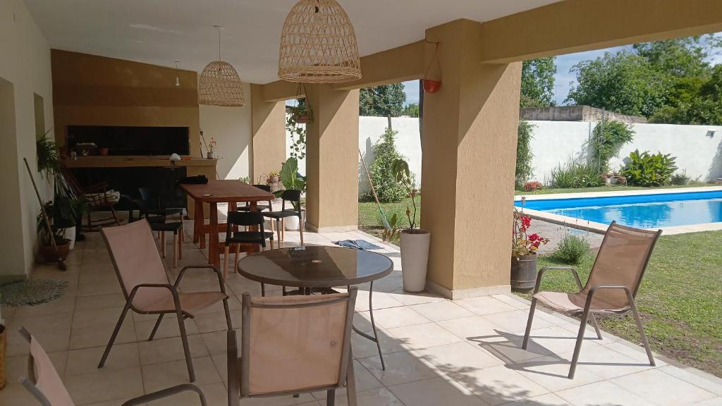 a patio with tables and chairs and a swimming pool at Doña Antonia in Albarellos