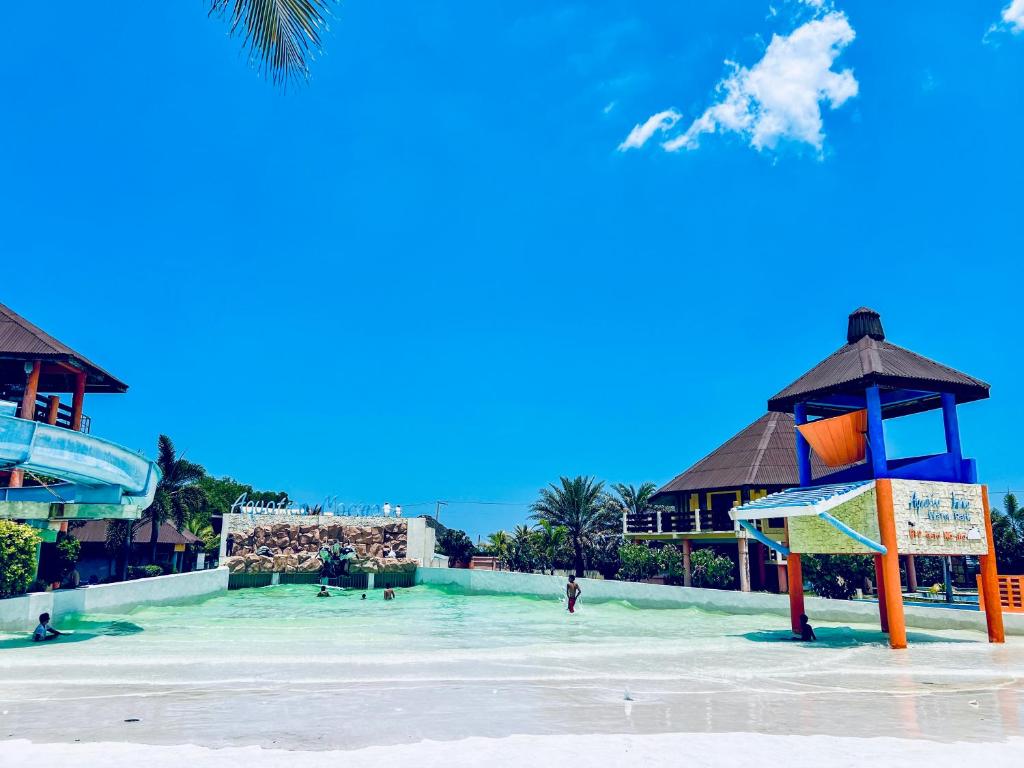 ein Pool in einem Resort mit Menschen im Wasser in der Unterkunft El Puerto Marina Beach Resort & Vacation Club in Lingayen