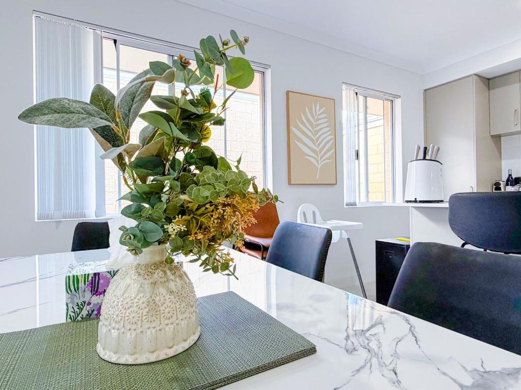 a vase filled with plants sitting on a table at Brabham Modern Stay Close to Swan Valley in West Swan