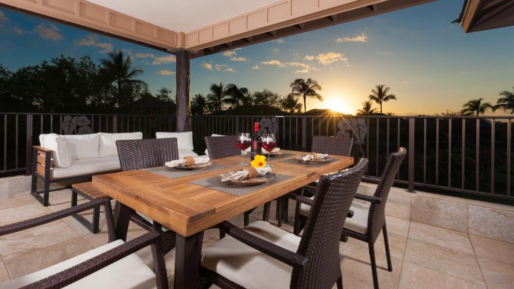 Una mesa y sillas de madera en un patio. en SWEET HEAVEN Upscale 4BR KaMilo Home with Bikes and Golf Clubs, en Waikoloa