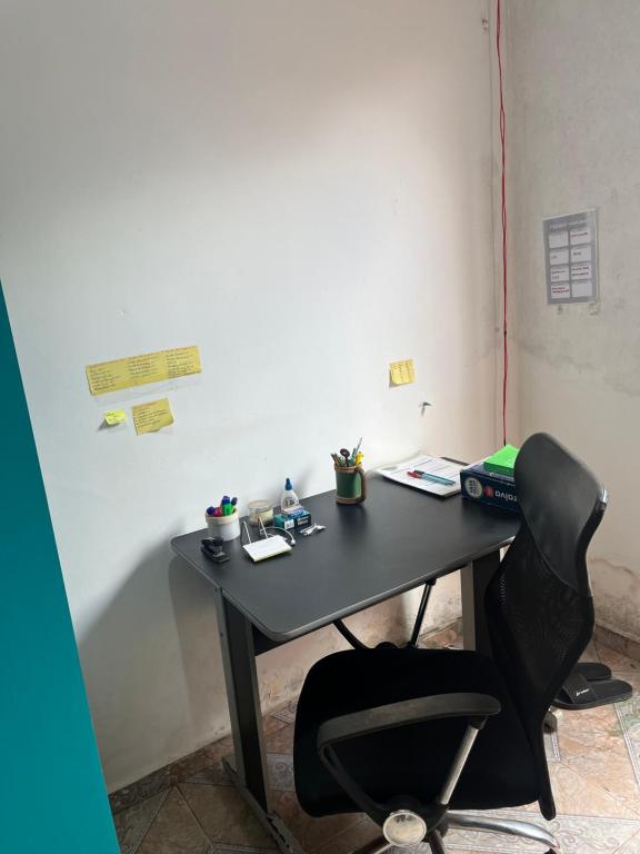 een zwart bureau met een stoel, pennen en notitieboekjes bij Stúdio Viajante in Barcarena