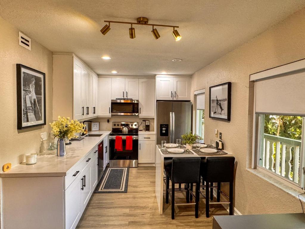 eine Küche mit weißen Schränken und einem Tisch mit Stühlen in der Unterkunft Close to Wilton Manors in Fort Lauderdale