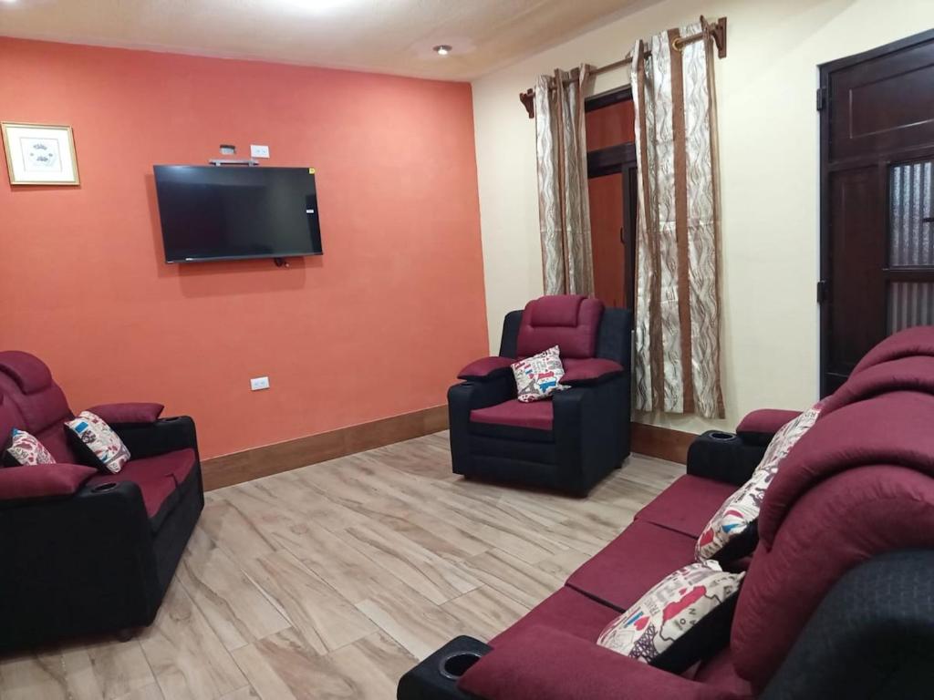a living room with couches and a flat screen tv at Casa Cifuentes in La Esperanza