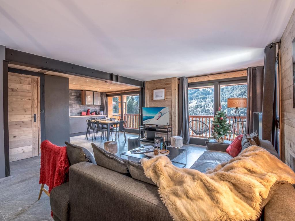 a living room with a couch and a table at Appartement rénové à Méribel, 3 chambres, accès skis, WIFI, parking - FR-1-688-99 in Mussillon