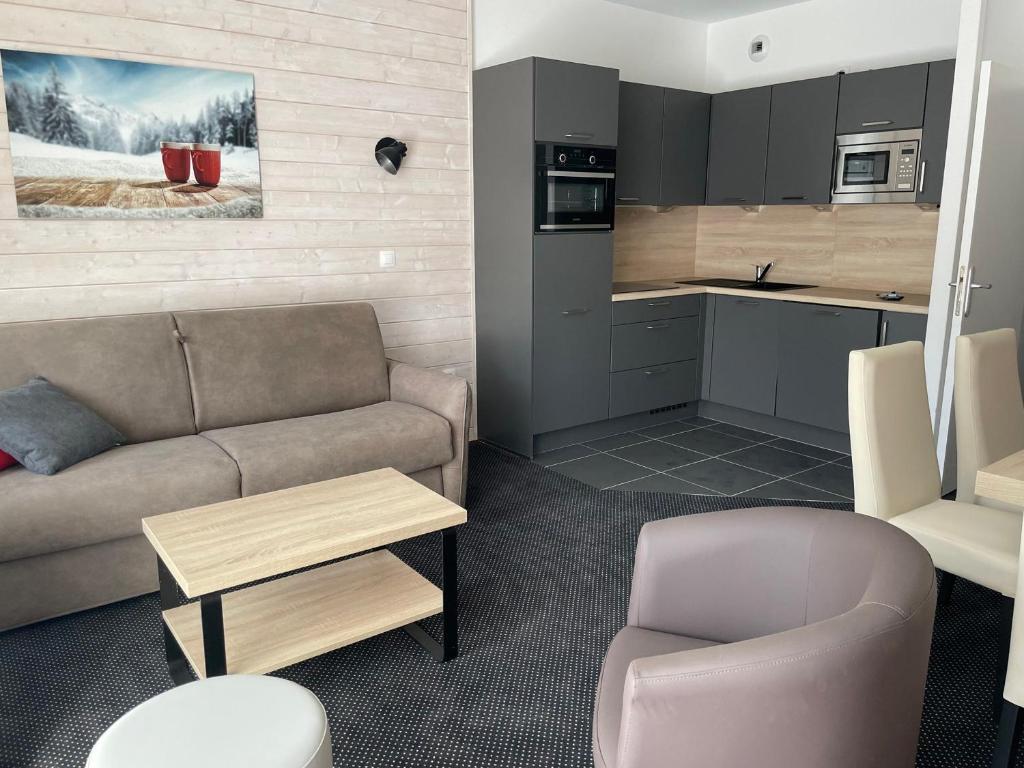 a living room with a couch and a kitchen at Charmant studio à Gourette avec piscine et animaux admis, pour 6 personnes - FR-1-860-26 in Gourette