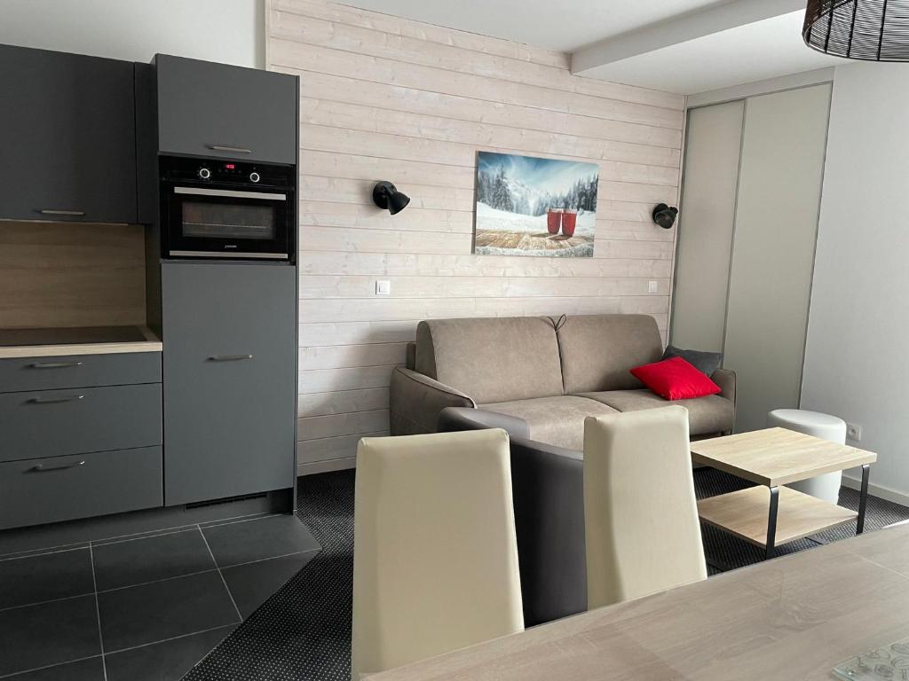 a kitchen and living room with a couch and a table at Studio 6 pers, piscine, animaux, Gourette - FR-1-860-37 in Gourette