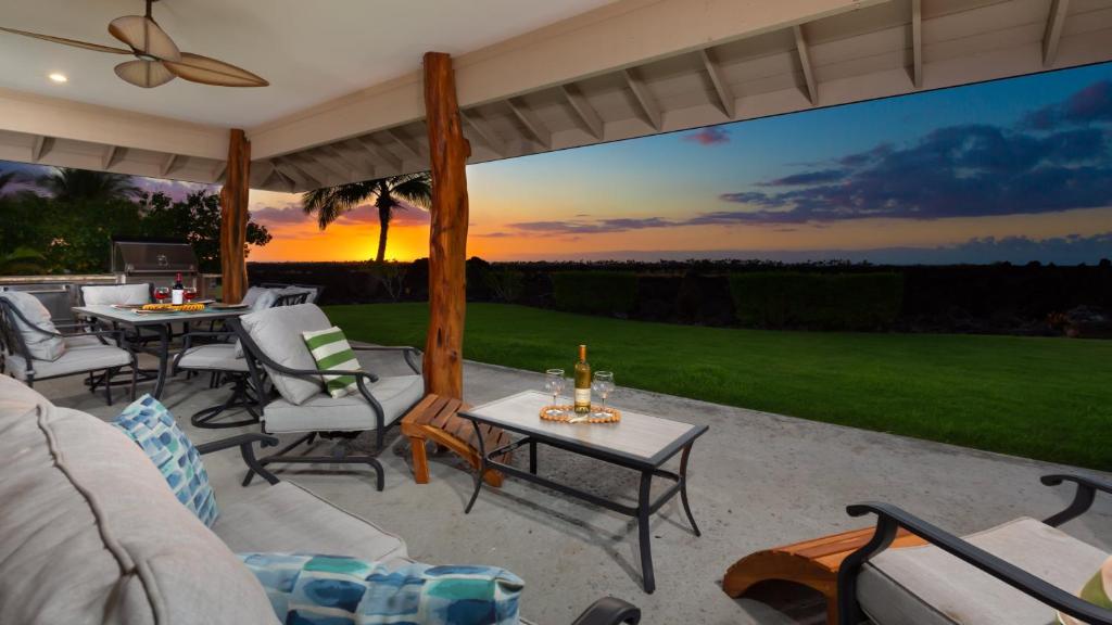 a patio with a couch and chairs and a table at SUNSET BREEZE Breezy 3BR Ainamalu Home for Large Families in Waikoloa