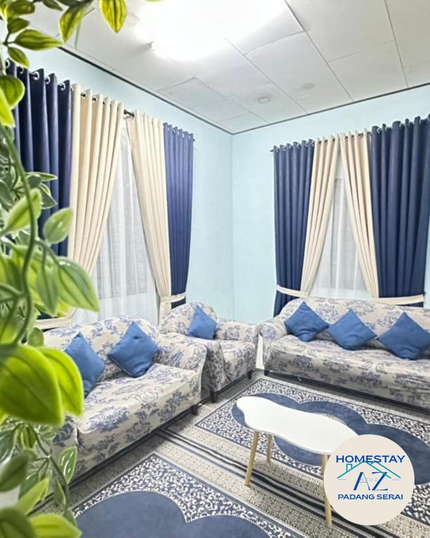 a living room with a couch and blue curtains at Homestay AZ Padang Serai in Padang Serai