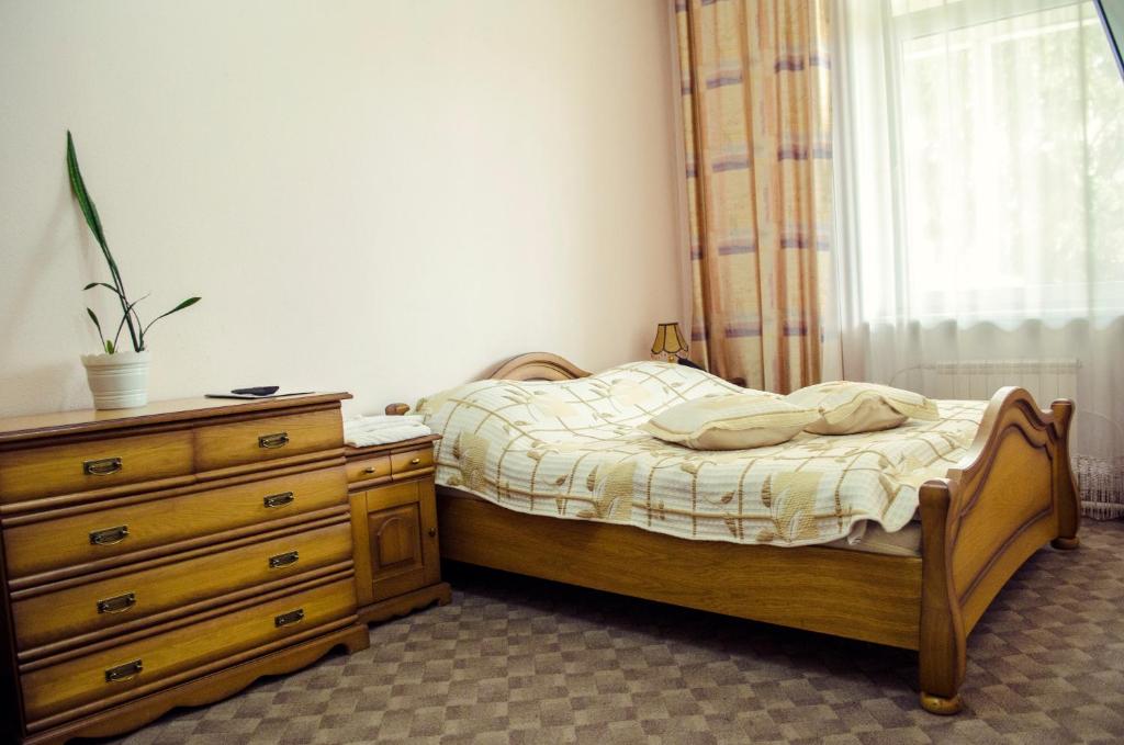 a bedroom with a bed and a dresser and a window at Filvarki-Centre in Kamianets-Podilskyi