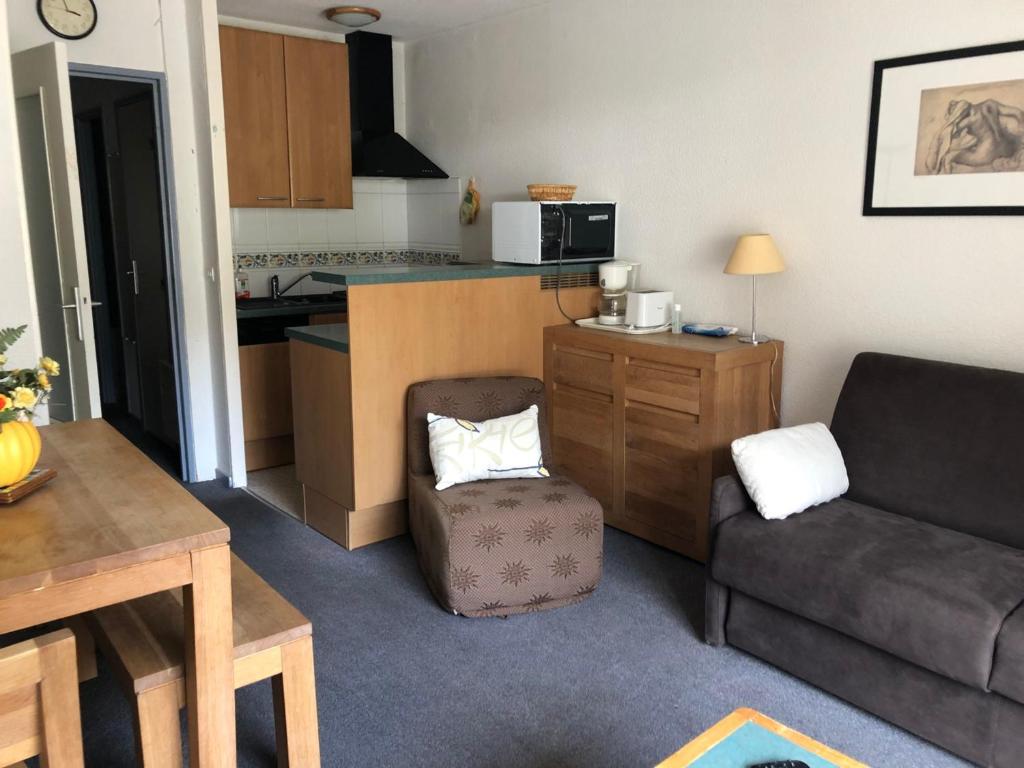 ein Wohnzimmer mit Couch und Küche in der Unterkunft Studio confort à Gourette pour 4 pers, animaux admis - FR-1-859-15 in Gourette