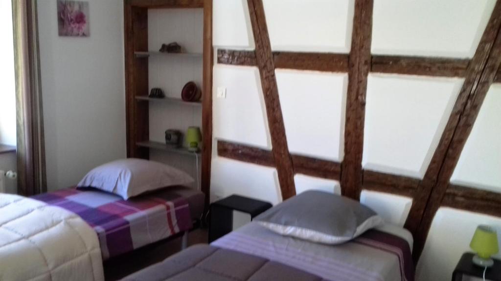 a bedroom with two beds and two windows at Gite Notre Dame in Rouffach
