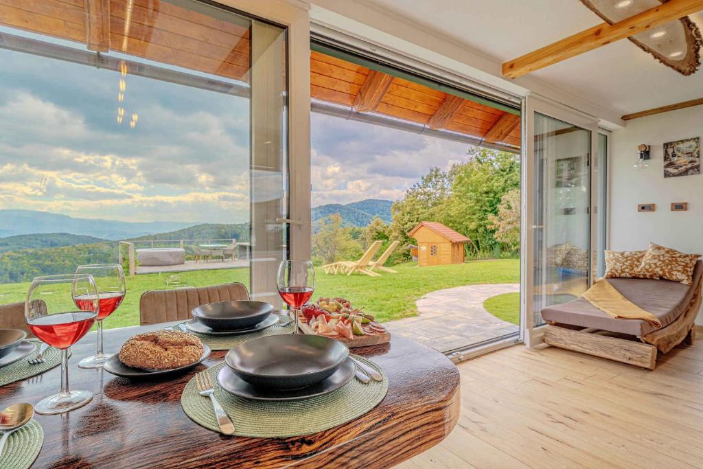 einen Tisch mit Speise- und Weingläsern und ein großes Fenster in der Unterkunft Holiday home in Trebelno - Dolenjska & Bela krajina (Unter- & Weißkrain) 54728 in Šmarjeta