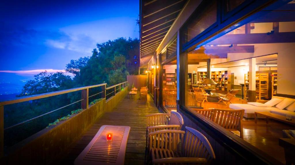 a balcony with chairs and a table on a building at Kaze no Tani no Iori in Gamagori