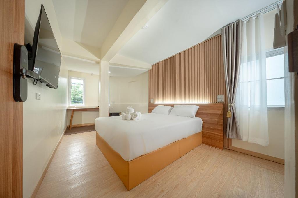 a bedroom with a bed and a flat screen tv at The Nook Hotel in Chiang Mai