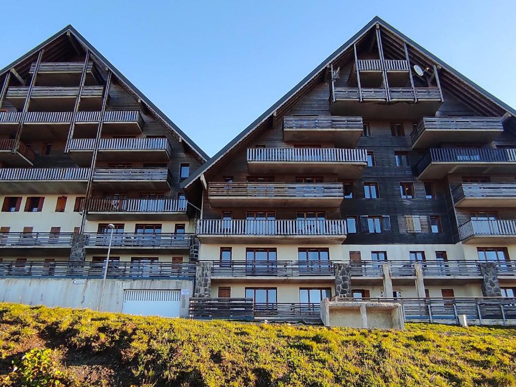 a large apartment building with balconies on a hill at Appartement Super Besse - 6 pers, Piscine, Parking, Balcon - FR-1-814-168 in Vassivière