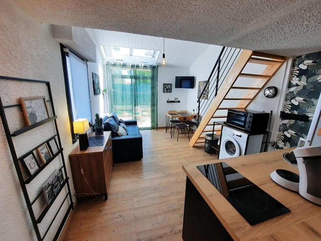 a living room with a couch and a staircase at Maisonnette rénovée proche plage avec animaux acceptés et parking - FR-1-194-319 in La Faute-sur-Mer