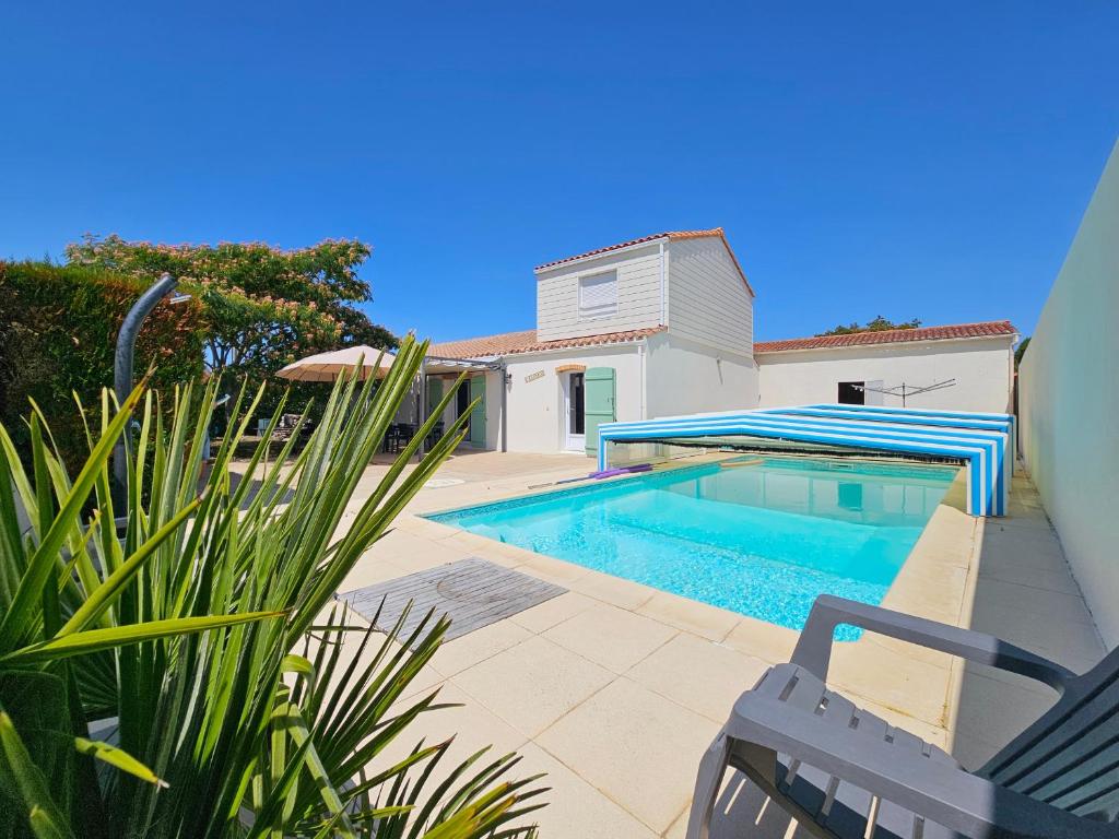 a swimming pool in front of a house at Maison spacieuse avec jardin, animaux admis - FR-1-476-250 in La Faute-sur-Mer