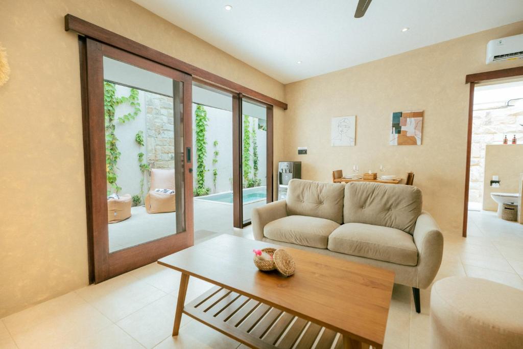 Una sala de estar con un sofá y una mesa de café. en Villa Akuta, en Kuta Lombok
