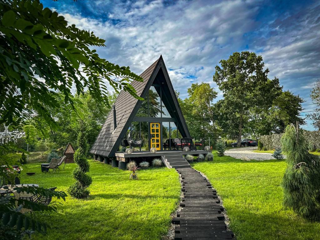 a small house in the middle of a grassy field at Porumbacu Garden in Porumbacu de Sus