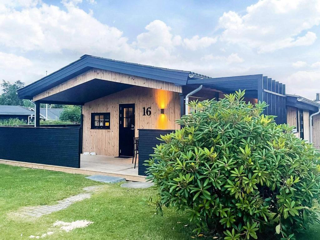 a small house with a black roof at Renovated Beach House - By Traum Ferienwohnungen in Juelsminde