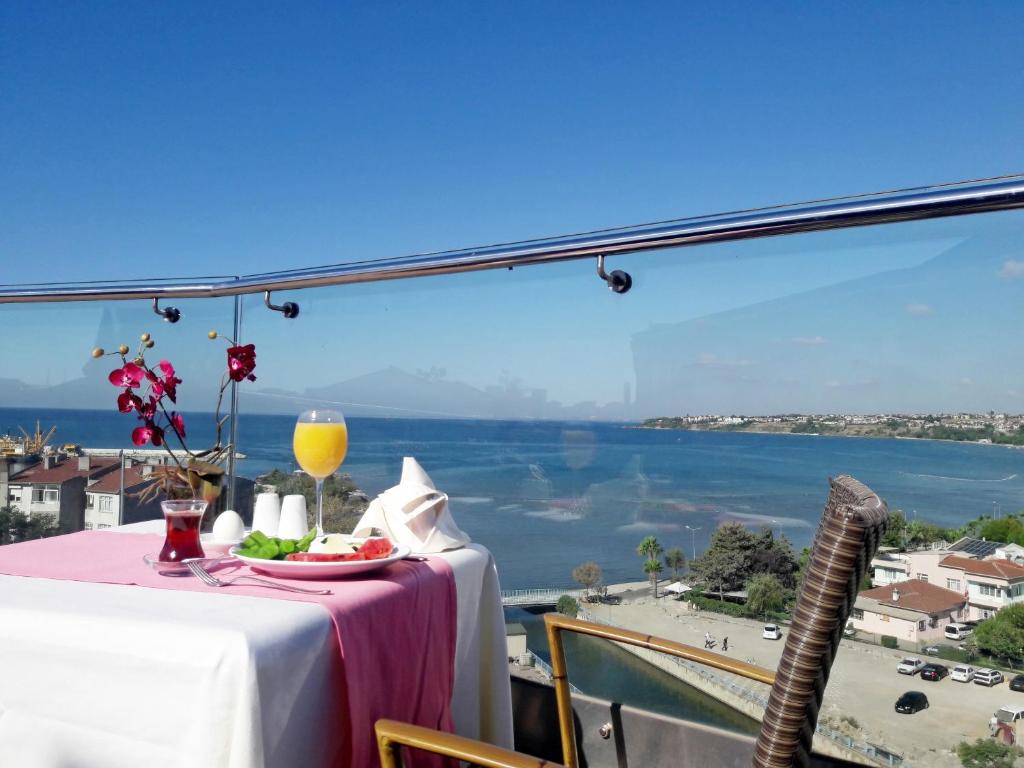 a table with a plate of food and a view of the ocean at Silivri Park Hotel in Silivri