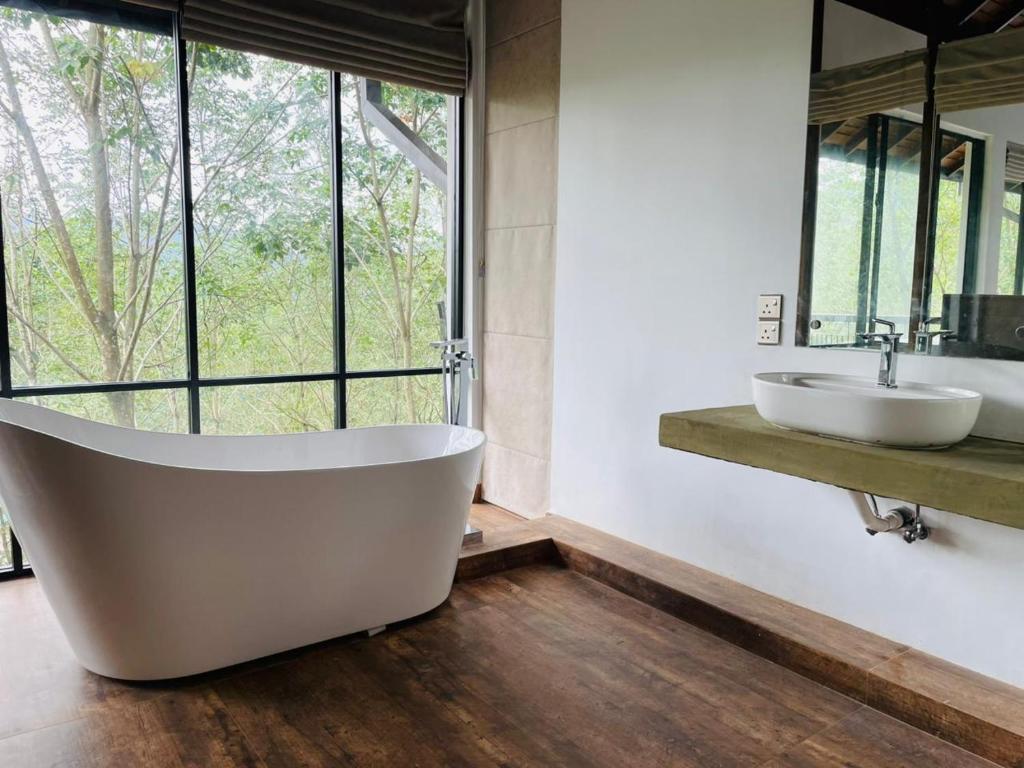 een badkamer met een groot bad en 2 wastafels bij Leaf Olu Ella in Yatiyantota