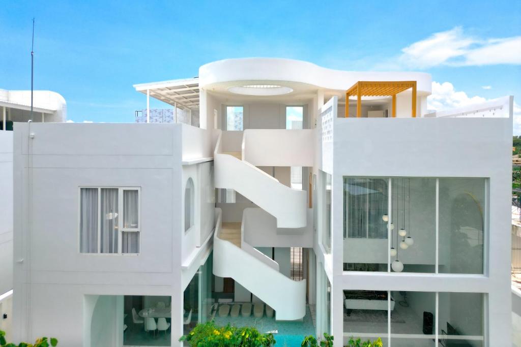 a white apartment building with white balconies at The Pool Space Pool Villa Pattaya A2 พูลวิลล่า in Ban Huai Yai