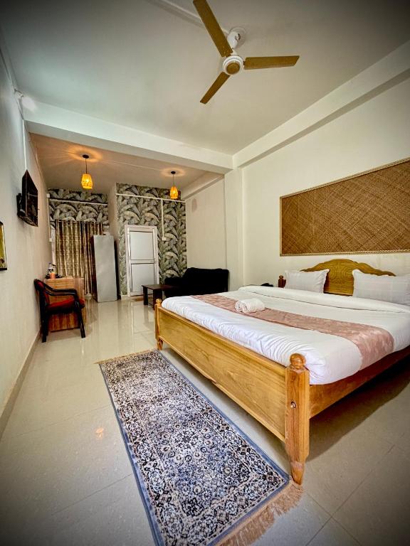 a bedroom with a large bed with a ceiling fan at Victus Emporium in Guwahati