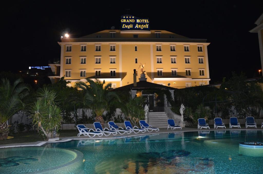 ein Hotel mit Stühlen und einem Swimmingpool in der Nacht in der Unterkunft Grand Hotel degli Angeli in San Giovanni Rotondo