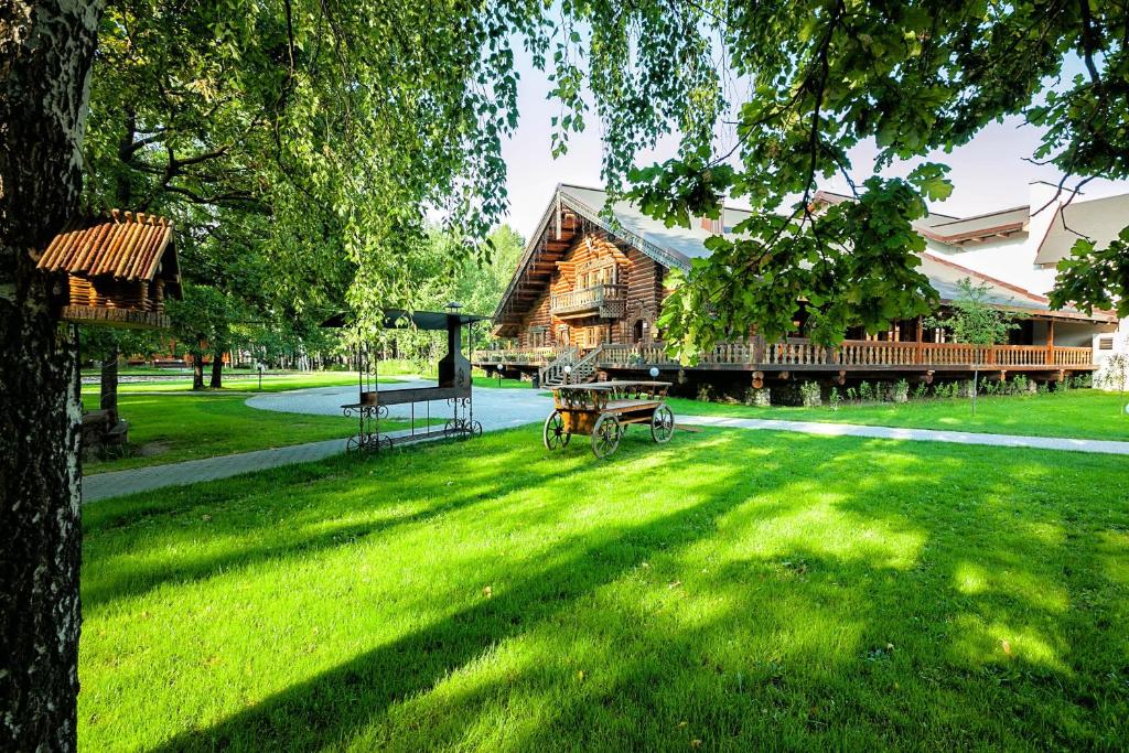 Cabaña de madera con mesa de picnic en el césped en Russkaya Derevnya, en Vladimir