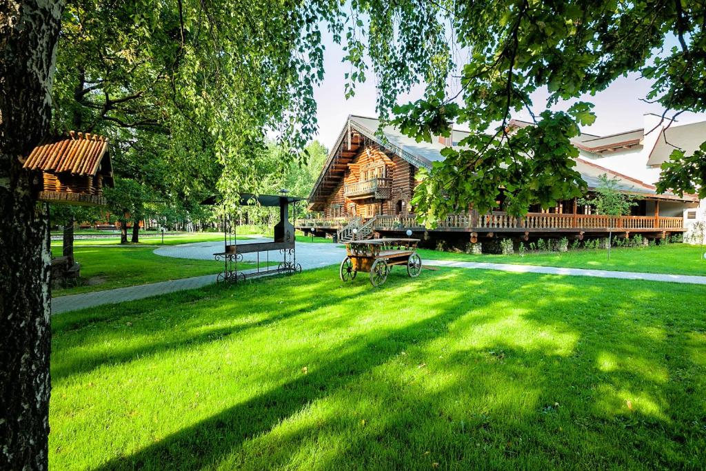 a log cabin with a picnic table in the grass at Russkaya Derevnya in Vladimir