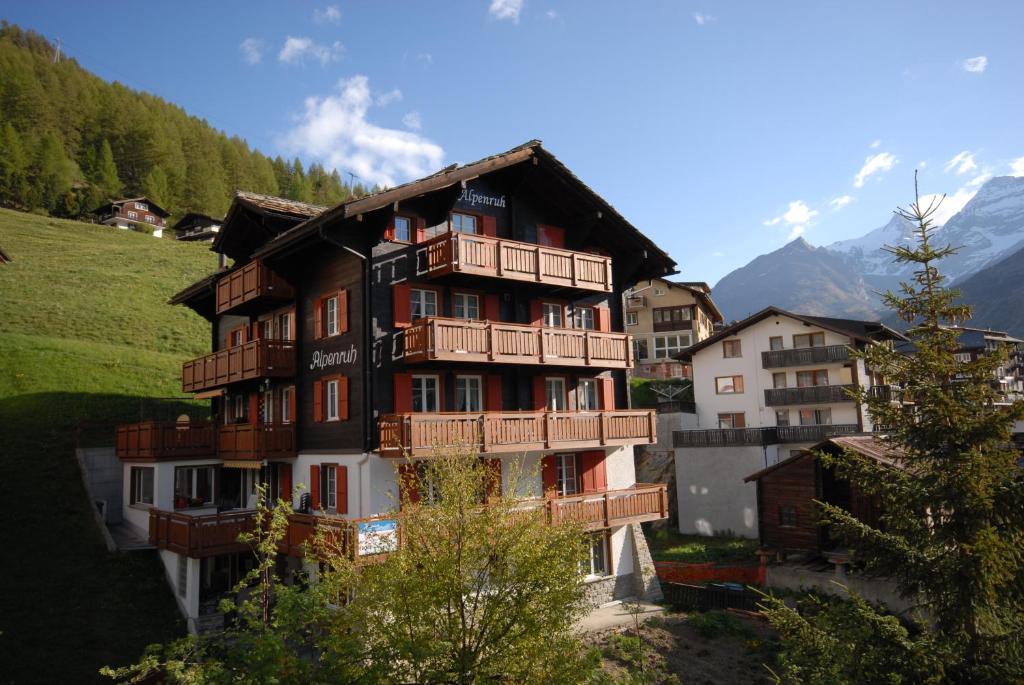 サースフェーにあるChalet Alpenruhの山の上に木製バルコニー付きの大きな建物