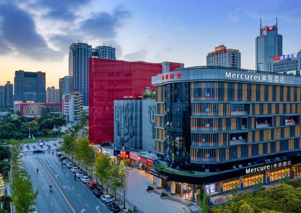 a city with a red building and a street with cars at Mercure Hotel in Xi'an