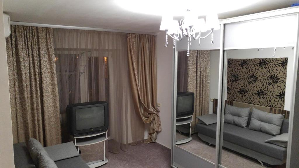 ein Wohnzimmer mit einem Sofa und einem TV in der Unterkunft Central Park Apartment in Dnipro