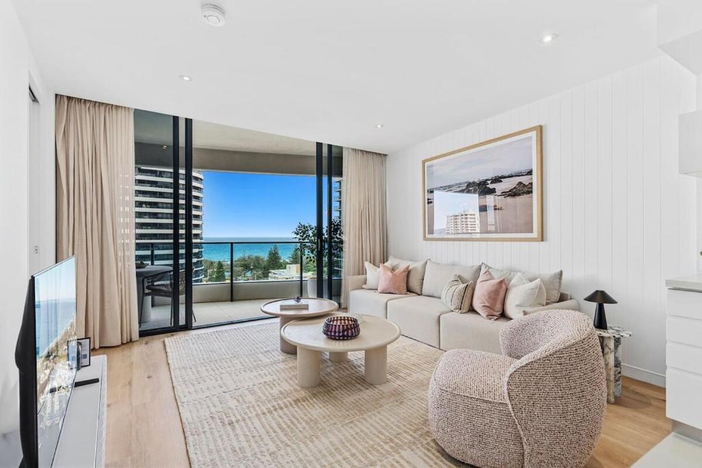 a living room with a couch and a table at Luxurious 2-Bed Designer Retreat at Oracle Resort in Gold Coast