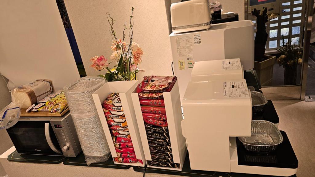 a counter topped with boxes of food and a microwave at 더 갤러리 호텔 in Suwŏn-yŏk