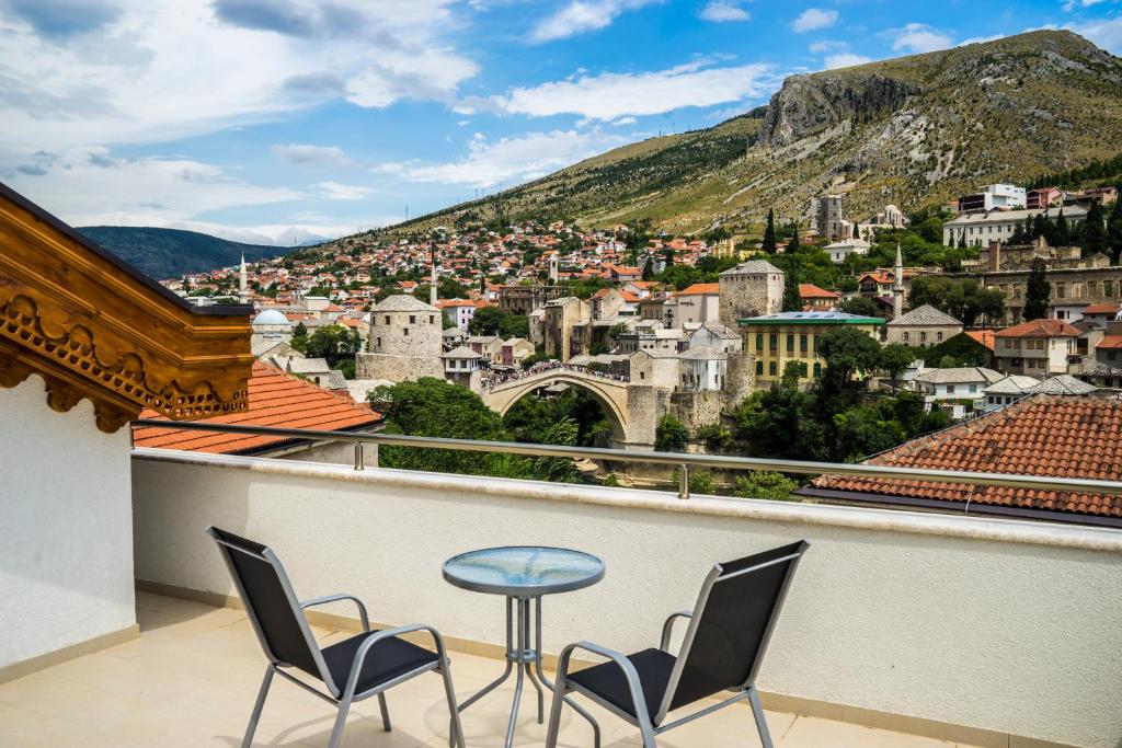 balkon z krzesłami i widokiem na miasto w obiekcie Hotel Kapetanovina w mieście Mostar