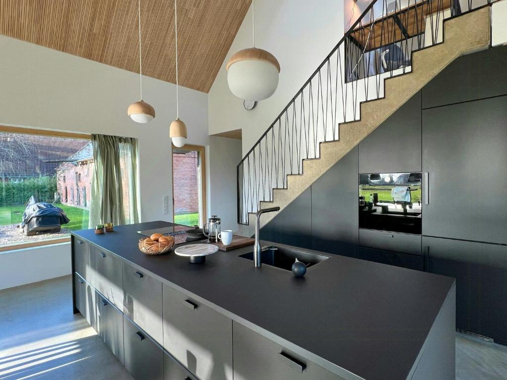 a kitchen with a black counter and a staircase at Architect's House With Nature View 