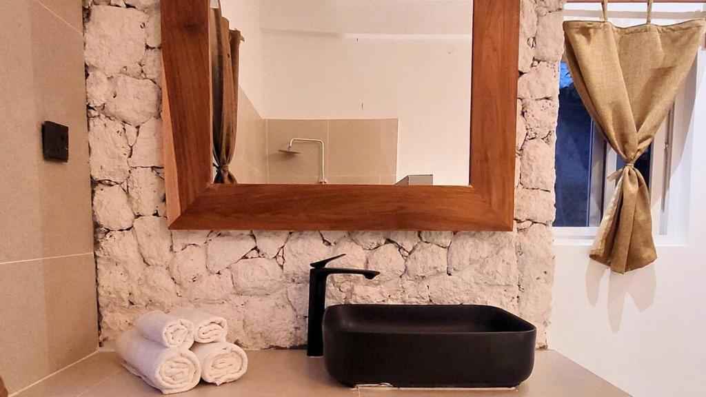 a bathroom with a black sink and a mirror at Paje Beach Zanzibar Private Luxury Villa with pool AC WIFI TV 90m walk to beach central location walk to shops bars & restaurants in Paje