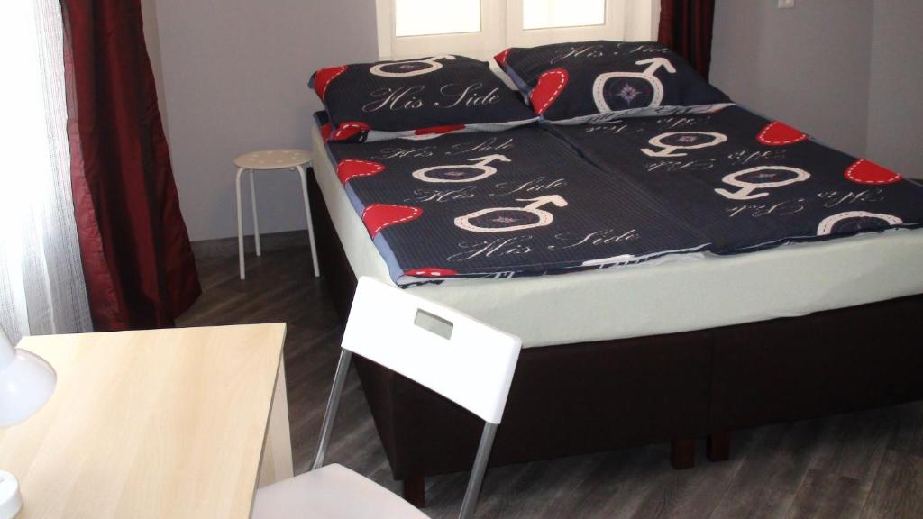a bed with a black comforter with eyes on it at Hostel Kamienna Centrum in Katowice