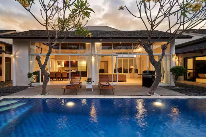 a swimming pool in front of a house at Villa Umasari Keramas in Keramas