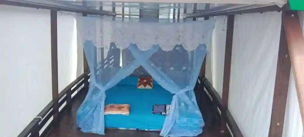 a bed in a room with a curtain at Orangutan Borneo Tour Tanjung Puting in Pangkalan Bun