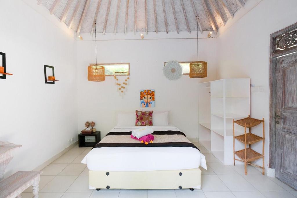 a bedroom with a bed in a white room at Villa Beji Ayu Seminyak - 2 Bedroom Private Pool in Seminyak