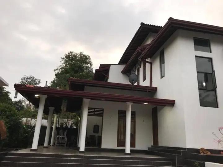 a white house with a porch and stairs at Chapa Resting Place in Dickwella