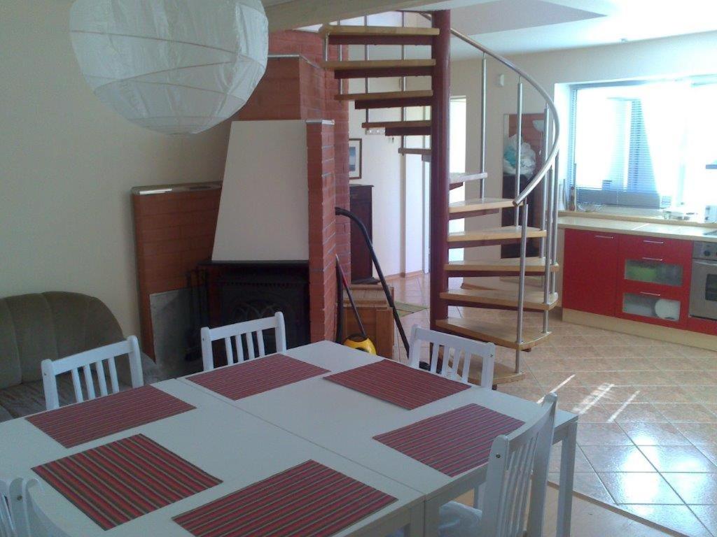a dining room with a table and chairs and a kitchen at Auli Beach Area Holiday Home in Pärnu