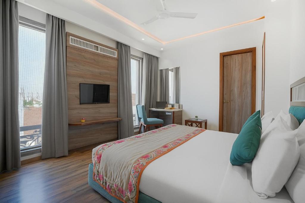 アムリトサルにあるHotel SG Continental Amritsar !! Prime Location ! Parking ! Open terraceのベッドとテレビがあるホテルの部屋