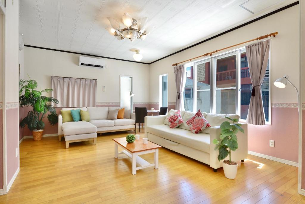 a living room with a couch and a table at 海徒歩1分アメリカンビレッジまで7分周辺には飲食店多数の北谷エリアSunabeNest in Chatan
