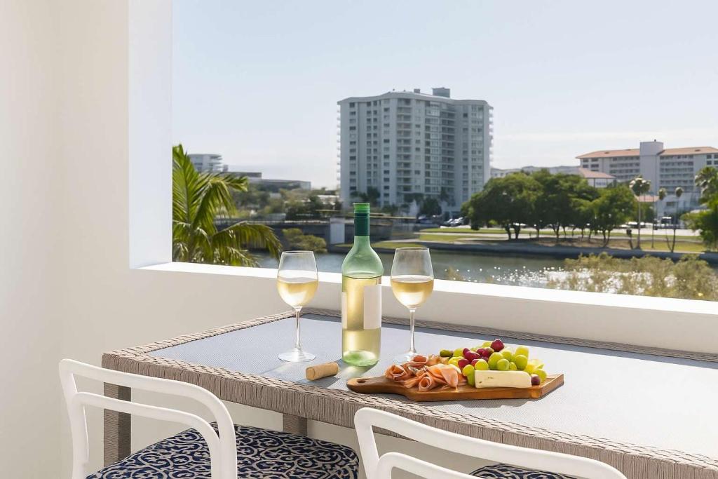 una mesa con dos copas de vino y un plato de comida en CBD Apartment with River Views Pool & Parking in Townsville, en Townsville