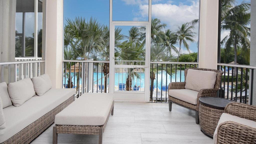 a balcony with a couch and chairs and palm trees at 409 Mariners Club in Key Largo